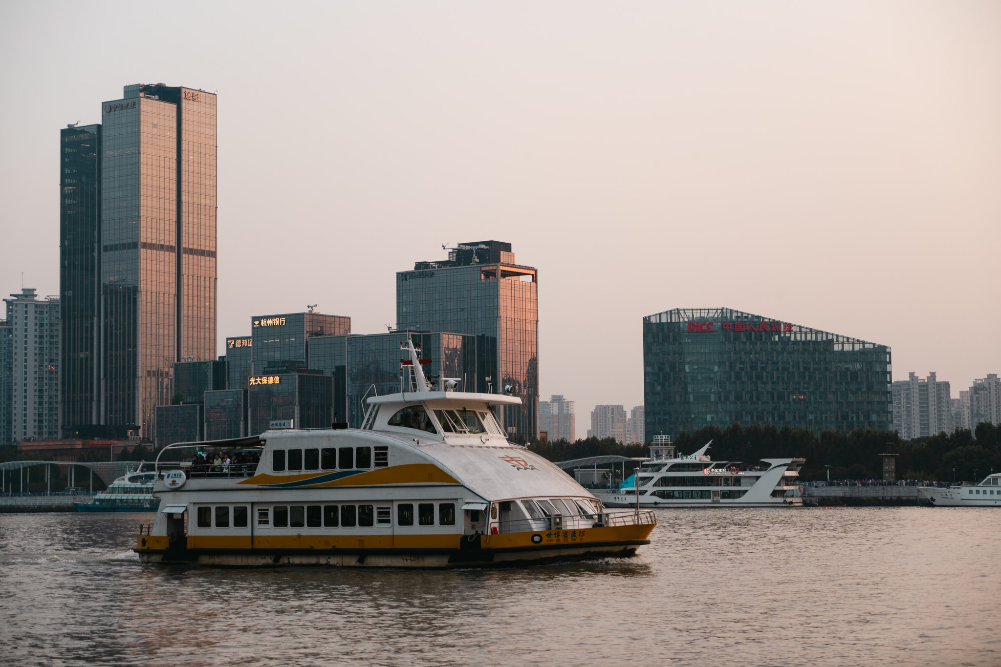 boat cruising on the river with a city skyline in the early evening
