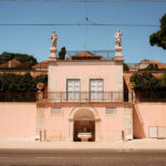 Pink building with statues and fountain in Lisbon.