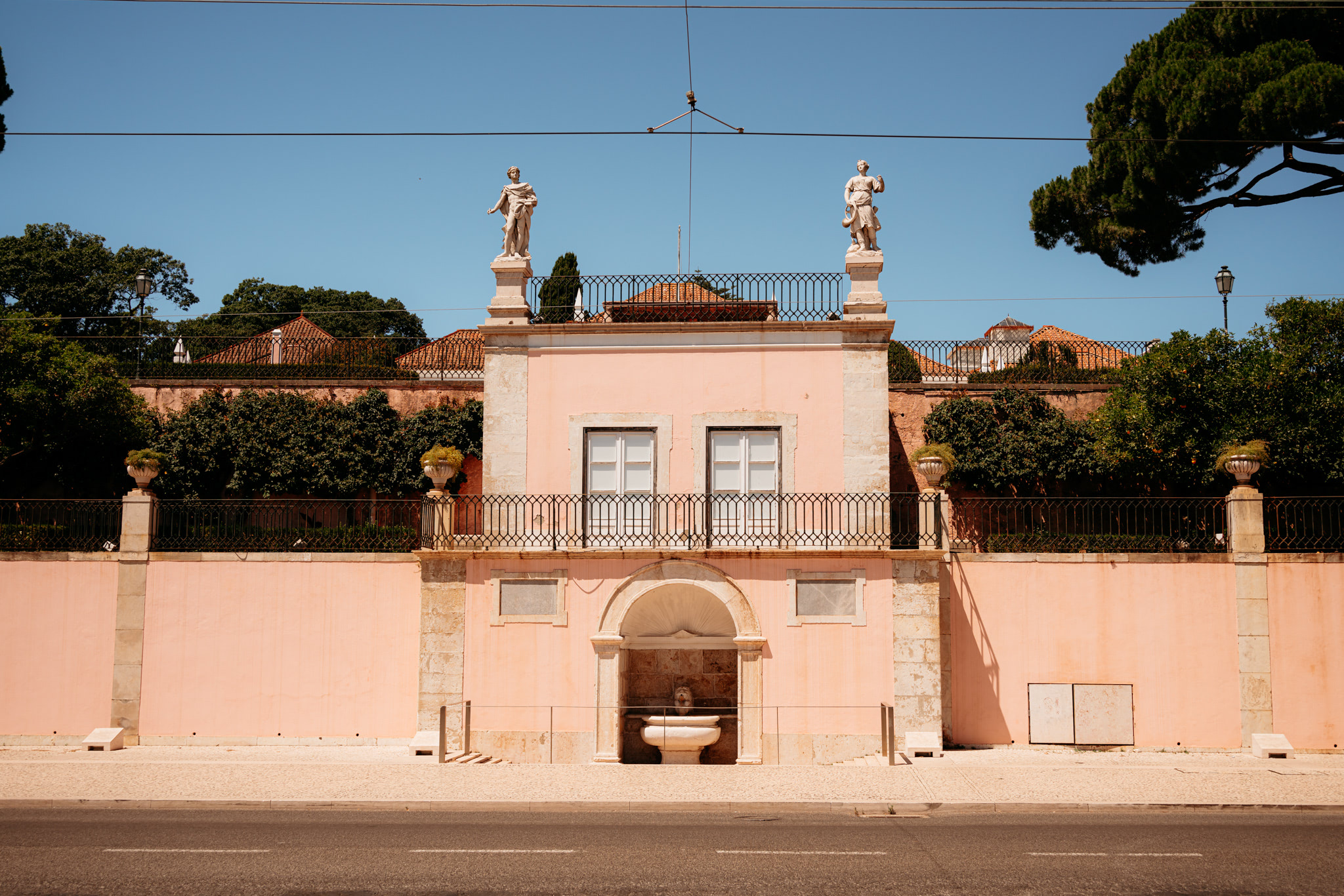 Pink building with statues and fountain in Lisbon.